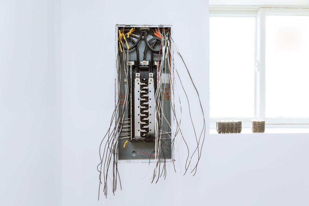 An open household breaker panel with its cover off and the circuit wiring visible
